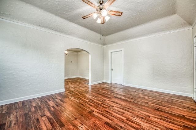 empty room with dark hardwood / wood-style flooring, ceiling fan, crown molding, and a textured ceiling