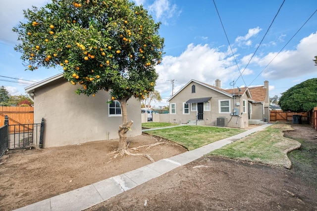 view of front of property with a front lawn and central air condition unit