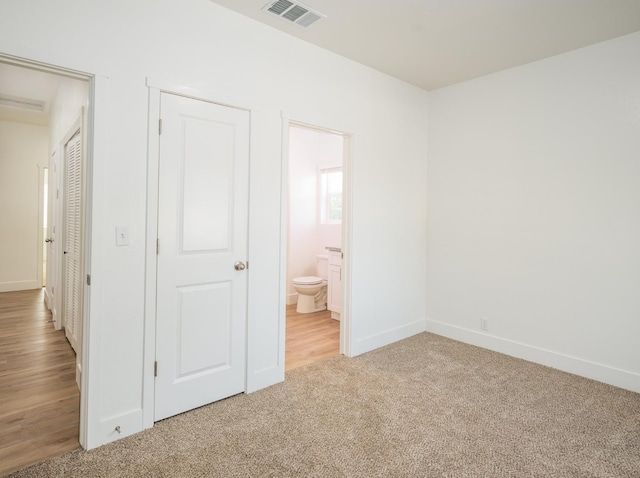 unfurnished bedroom featuring connected bathroom and light hardwood / wood-style floors