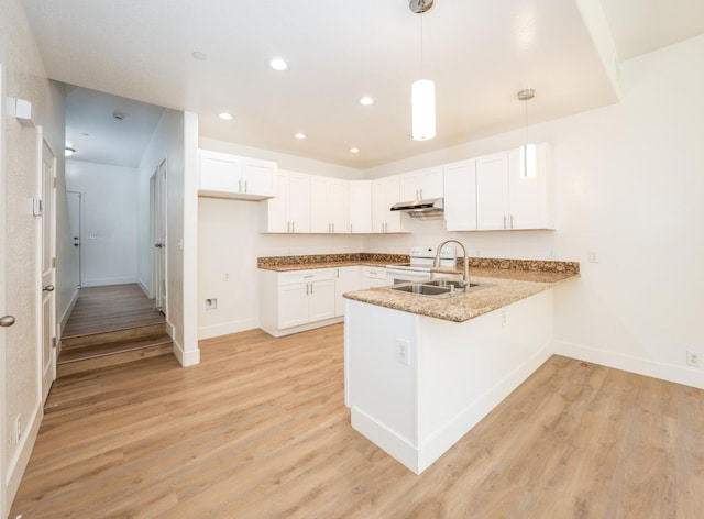 kitchen with white cabinets, kitchen peninsula, hanging light fixtures, and light hardwood / wood-style flooring