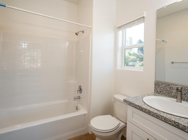 full bathroom featuring vanity, tiled shower / bath, and toilet