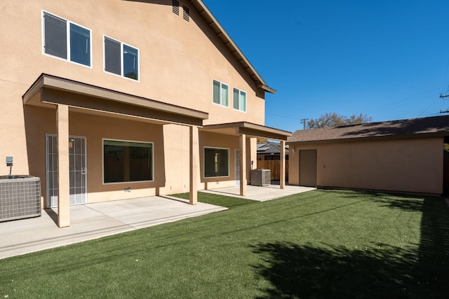 back of property featuring cooling unit, a lawn, and a patio