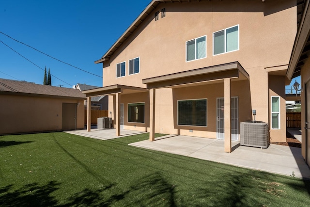 back of house featuring central air condition unit, a patio area, and a lawn