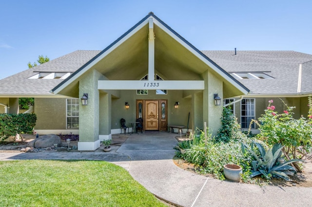 11333 E Church Ave, Sanger, CA 93657 - property entrance with stucco siding, roof with shingles, and a lawn