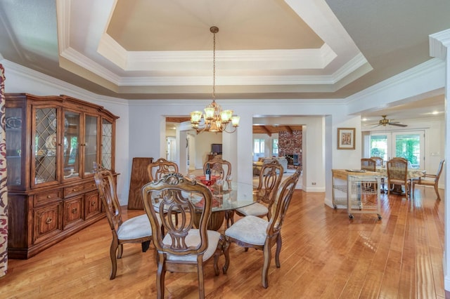11333 E Church Ave, Sanger, CA 93657 - dining area featuring a chandelier, light wood finished floors, crown molding, a tray ceiling, and a brick fireplace