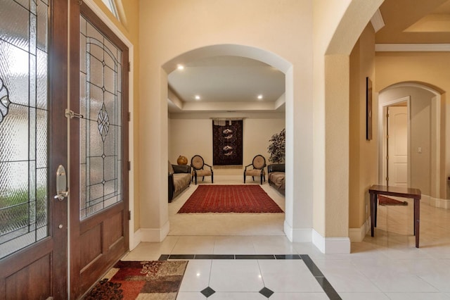 entrance foyer with french doors, a wealth of natural light, light tile patterned floors, and a tray ceiling