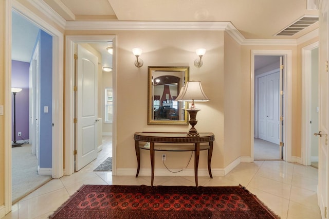 hallway with ornamental molding and light tile patterned flooring