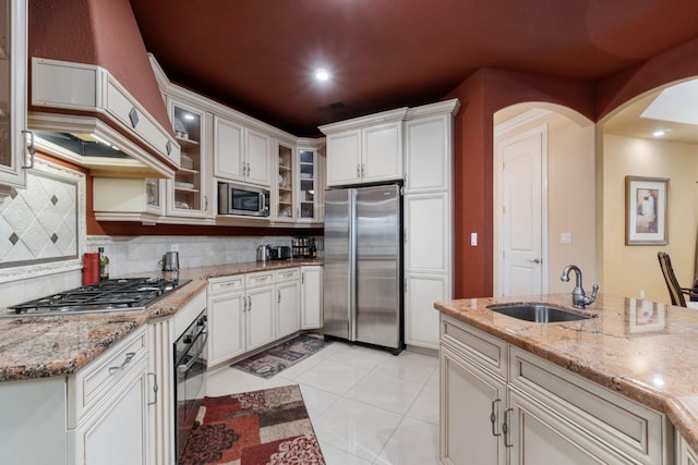 kitchen featuring stainless steel appliances, light stone countertops, and tasteful backsplash