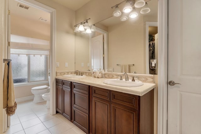 bathroom with tile patterned flooring, a bidet, toilet, and vanity