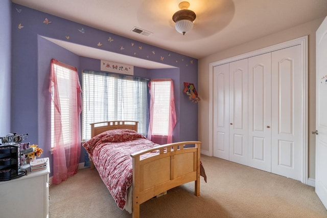 carpeted bedroom with ceiling fan and a closet