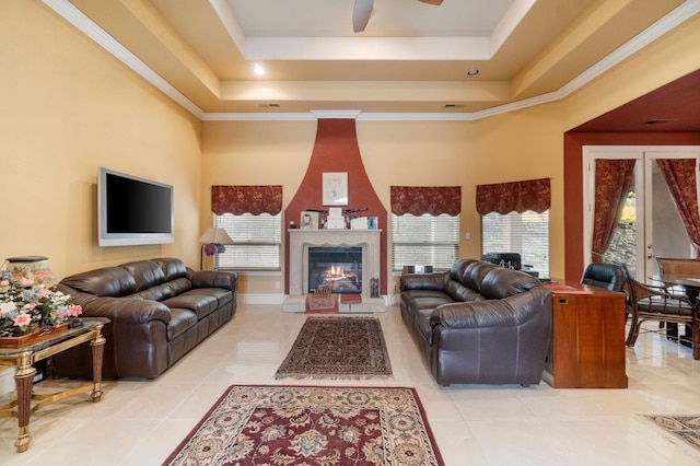 tiled living room featuring crown molding, plenty of natural light, and a raised ceiling