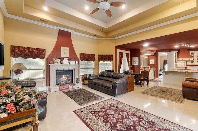 tiled living room featuring a fireplace, ceiling fan, plenty of natural light, and crown molding