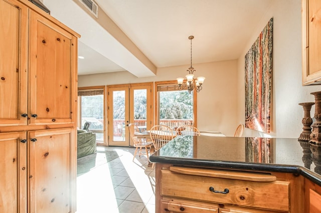 kitchen with french doors, light tile patterned floors, a notable chandelier, beam ceiling, and hanging light fixtures