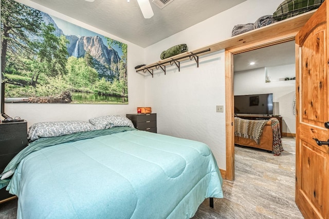 bedroom with hardwood / wood-style floors, vaulted ceiling, ceiling fan, and a textured ceiling