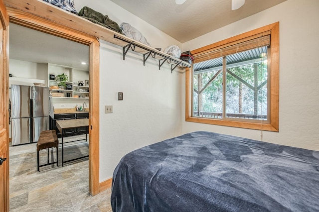 bedroom featuring stainless steel refrigerator and ceiling fan