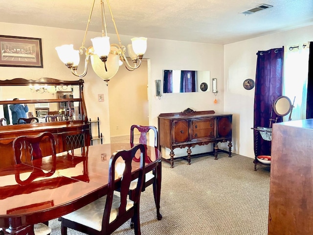 dining space featuring a notable chandelier, carpet floors, and a textured ceiling