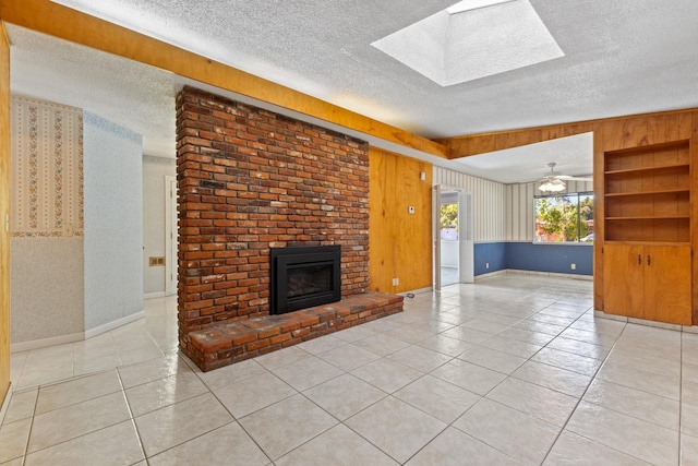 unfurnished living room featuring light tile patterned flooring, a fireplace, a skylight, and a textured ceiling