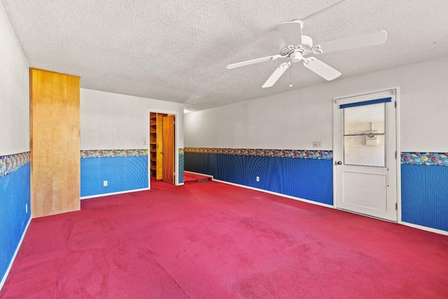 carpeted spare room with ceiling fan and a textured ceiling