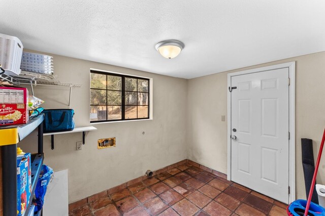 washroom with hookup for a washing machine and a textured ceiling