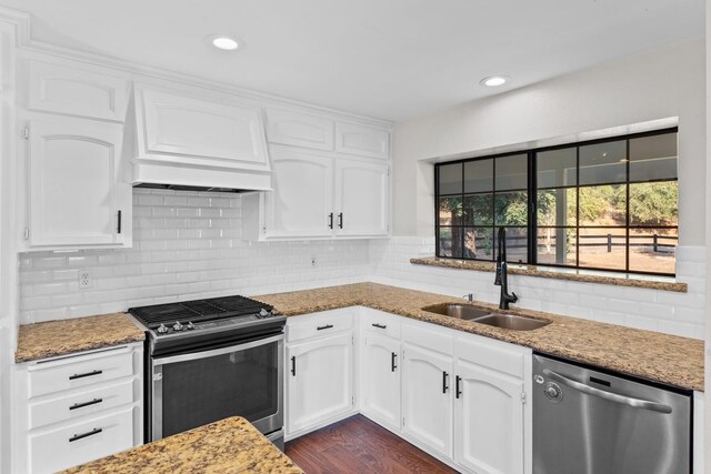 kitchen with sink, stainless steel appliances, dark hardwood / wood-style floors, stone countertops, and white cabinets