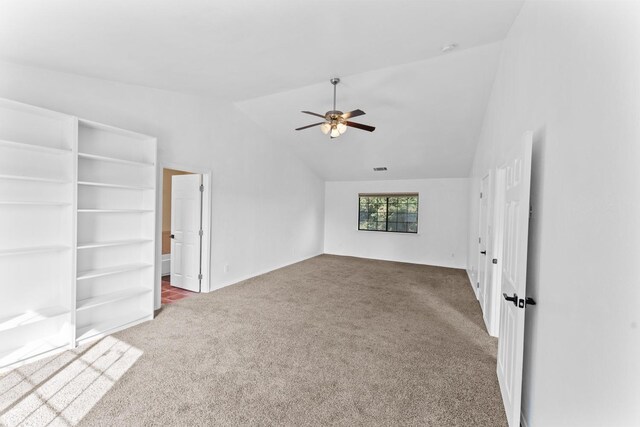 carpeted spare room featuring ceiling fan and lofted ceiling