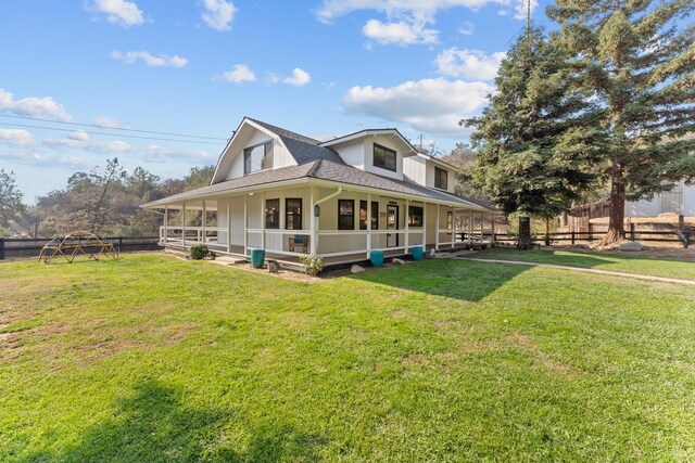 rear view of house featuring a yard