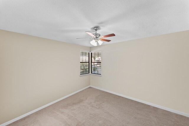 carpeted empty room featuring ceiling fan and a textured ceiling