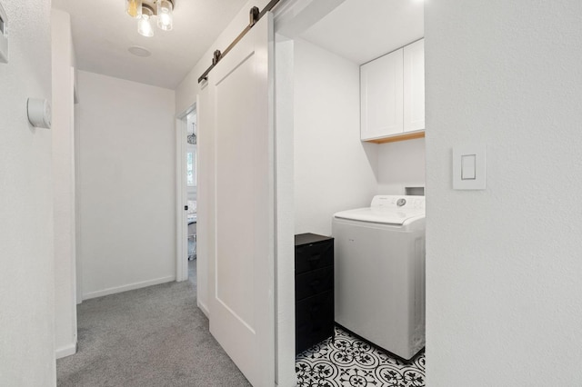 clothes washing area with washer / dryer, cabinets, a barn door, and light carpet