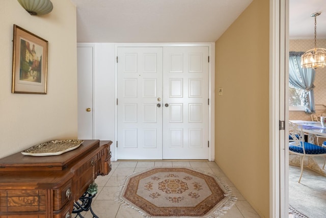 tiled foyer featuring an inviting chandelier