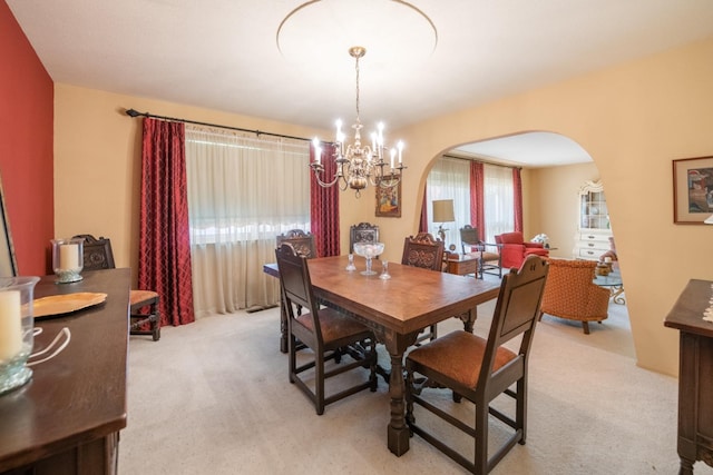 carpeted dining area featuring a notable chandelier