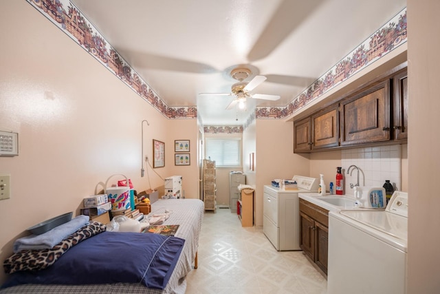 laundry area featuring cabinets, sink, ceiling fan, and washing machine and clothes dryer