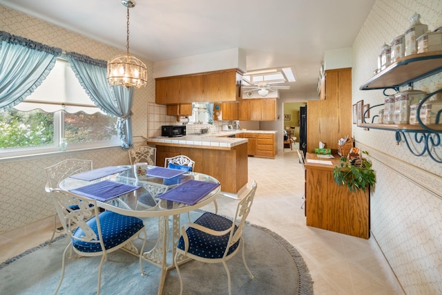 dining room featuring ceiling fan with notable chandelier