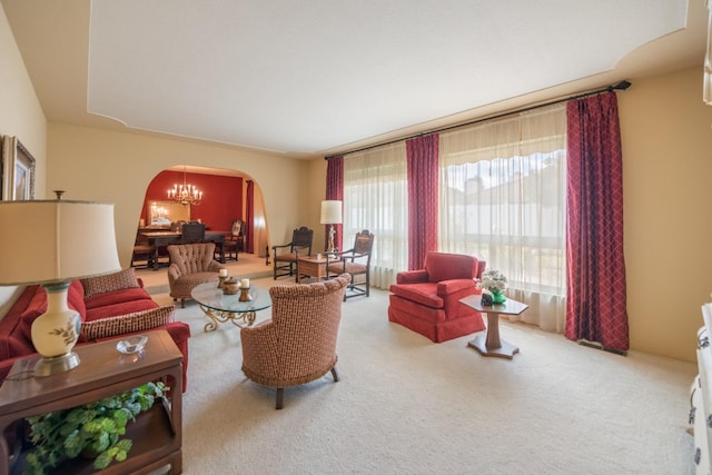 carpeted living room featuring a chandelier