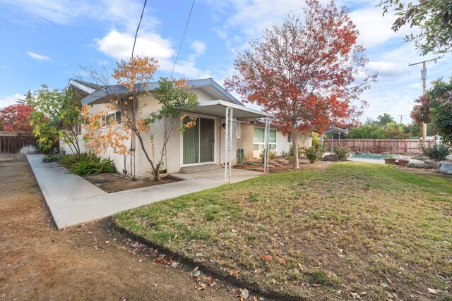 rear view of property featuring a yard, a fenced in pool, and a patio