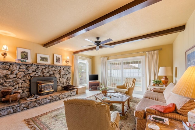 living room with carpet, a textured ceiling, ceiling fan, beamed ceiling, and a wood stove