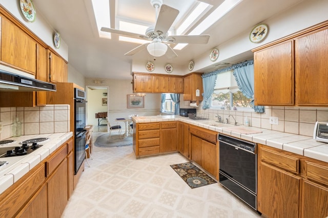 kitchen with ceiling fan, sink, backsplash, tile countertops, and black appliances