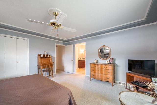 carpeted bedroom featuring ceiling fan, ornamental molding, connected bathroom, and a closet