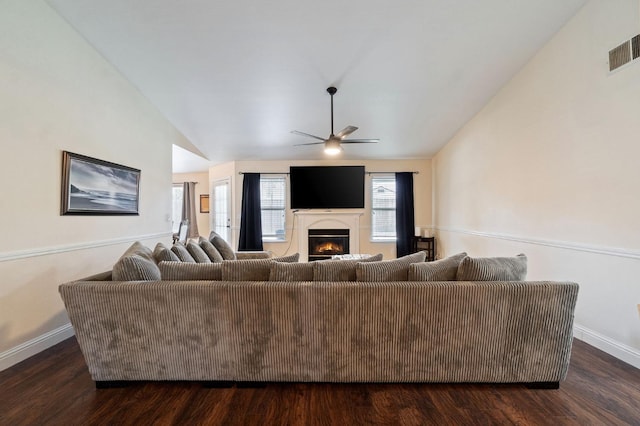 living room featuring dark hardwood / wood-style floors, vaulted ceiling, and ceiling fan