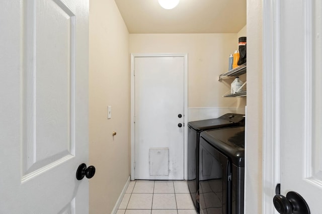 washroom featuring light tile patterned floors and washer and clothes dryer