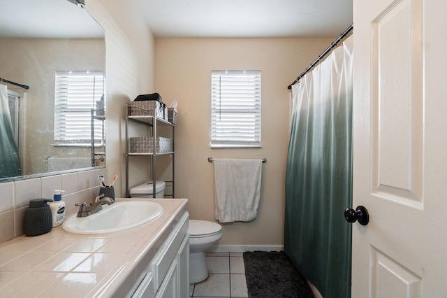 bathroom with tile patterned flooring, vanity, toilet, and tasteful backsplash