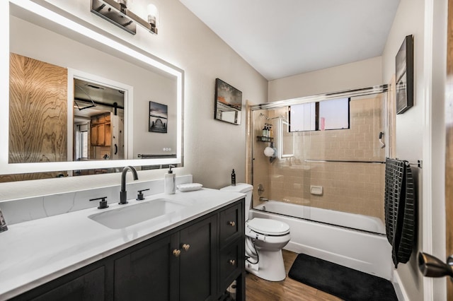 full bathroom featuring wood-type flooring, vanity, toilet, and enclosed tub / shower combo