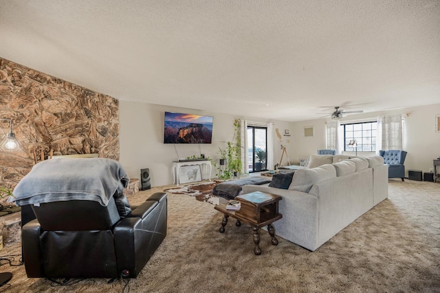 living room featuring ceiling fan, a healthy amount of sunlight, and a textured ceiling