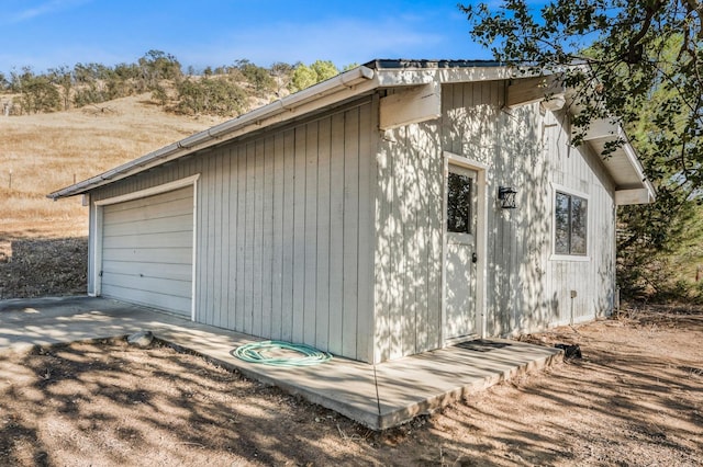 view of property exterior with an outdoor structure and a garage