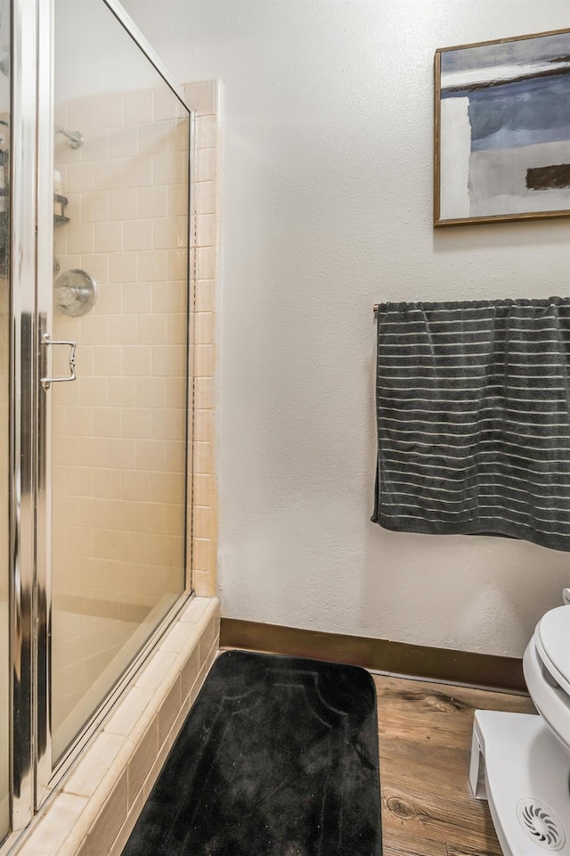 bathroom with an enclosed shower and toilet