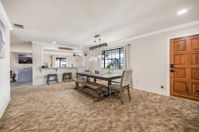 dining area with carpet, ceiling fan, and crown molding