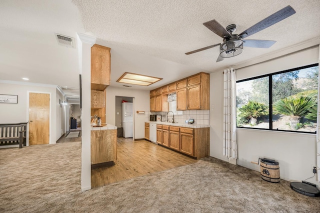 kitchen featuring light carpet, a textured ceiling, white appliances, ceiling fan, and crown molding