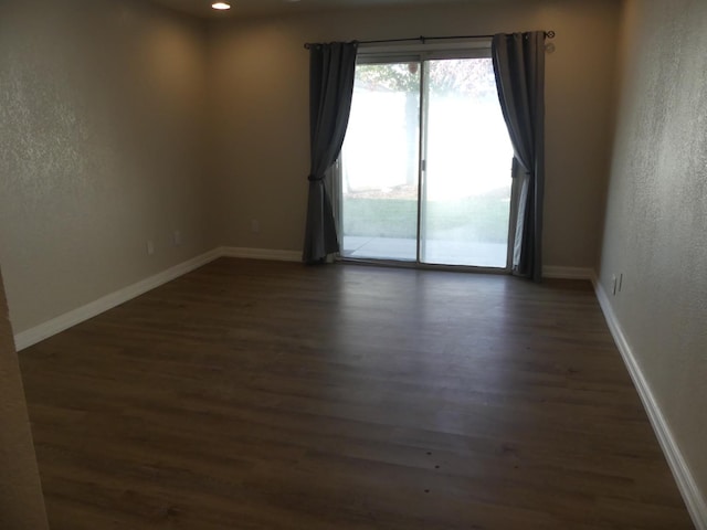 unfurnished room with dark wood-type flooring