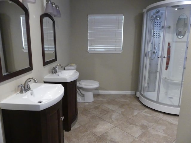 bathroom with tile patterned floors, vanity, an enclosed shower, and toilet