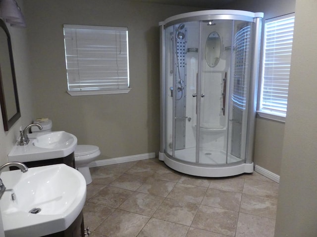 bathroom featuring tile patterned floors, vanity, toilet, and a shower with shower door