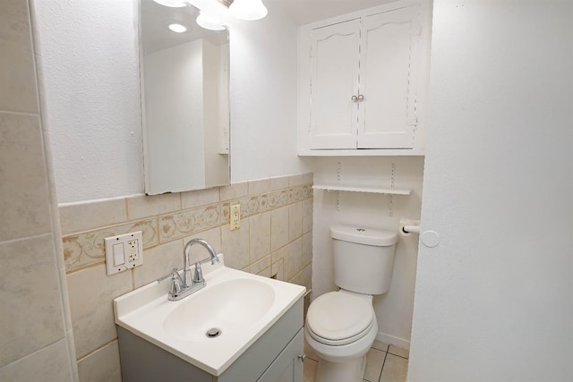 bathroom with tile patterned flooring, vanity, toilet, and tile walls